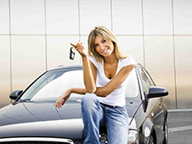 Woman sitting on hood of new car